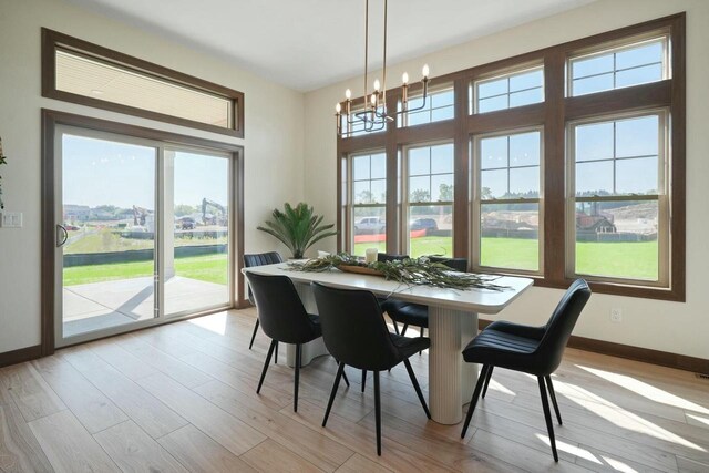 8437 Creek View Ln, Mount Pleasant, WI 53406 - dining room with light wood finished floors, baseboards, and a chandelier