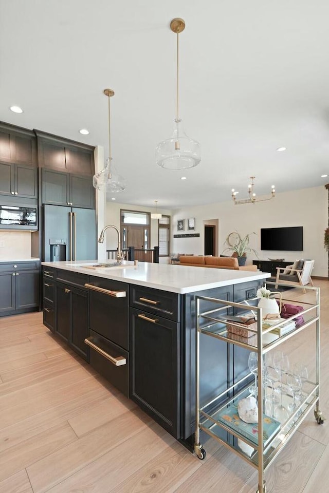 8437 Creek View Ln, Mount Pleasant, WI 53406 - kitchen with open floor plan, light wood-type flooring, a center island with sink, light countertops, and recessed lighting