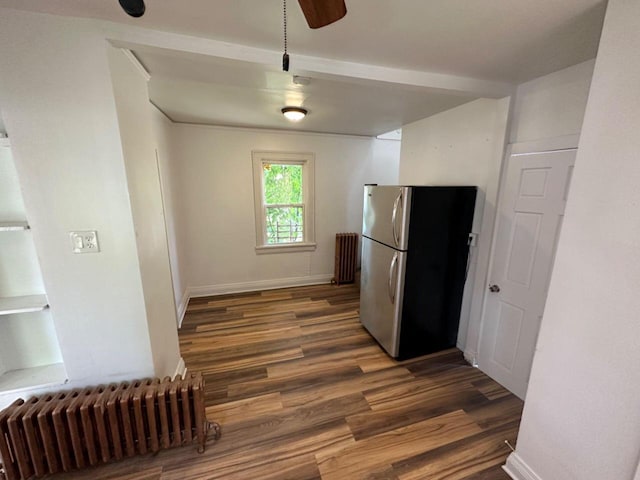 kitchen with radiator heating unit, baseboards, wood finished floors, and freestanding refrigerator