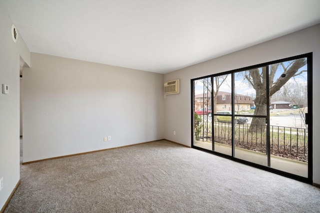 spare room with baseboards, an AC wall unit, and carpet
