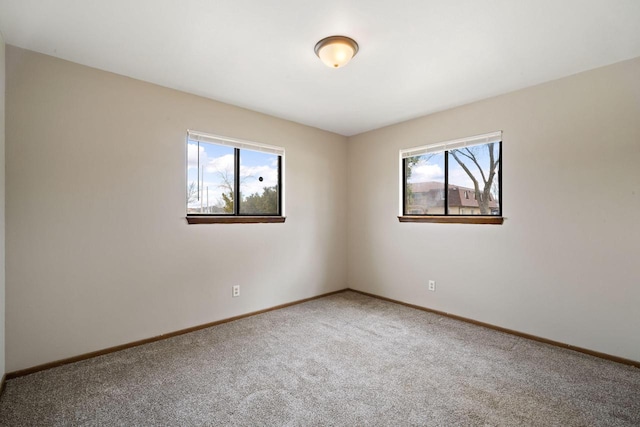 spare room featuring baseboards and carpet flooring