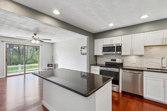 kitchen with white cabinetry, appliances with stainless steel finishes, decorative backsplash, and a sink