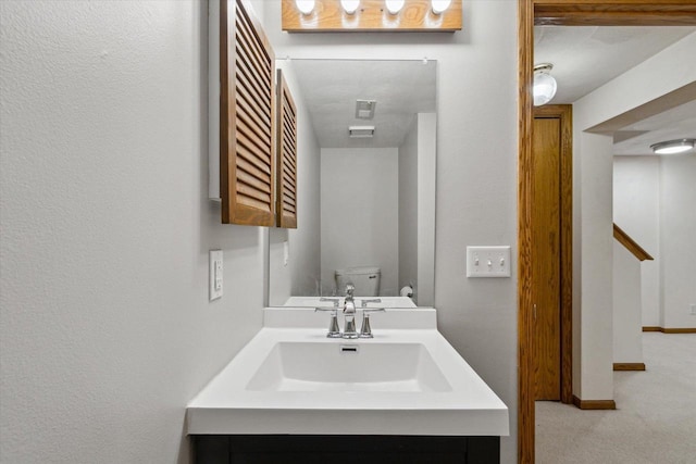 bathroom featuring toilet, baseboards, visible vents, and vanity