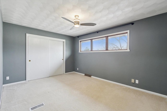 unfurnished bedroom featuring carpet, a closet, and visible vents