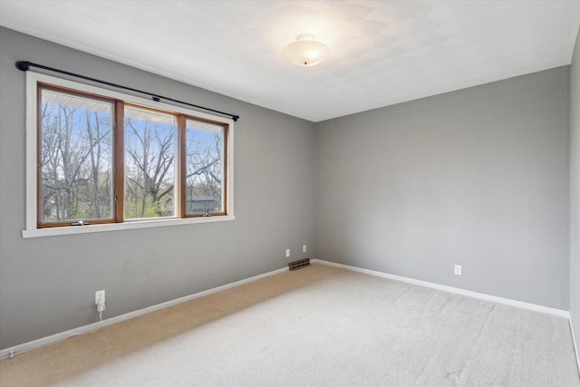 carpeted spare room with baseboards and visible vents