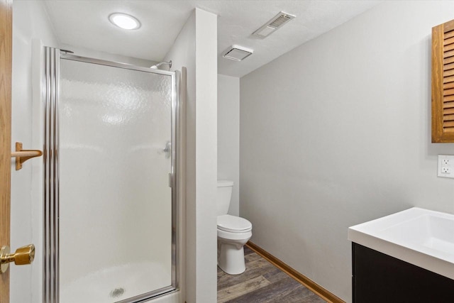 full bath featuring toilet, baseboards, wood finished floors, visible vents, and a stall shower