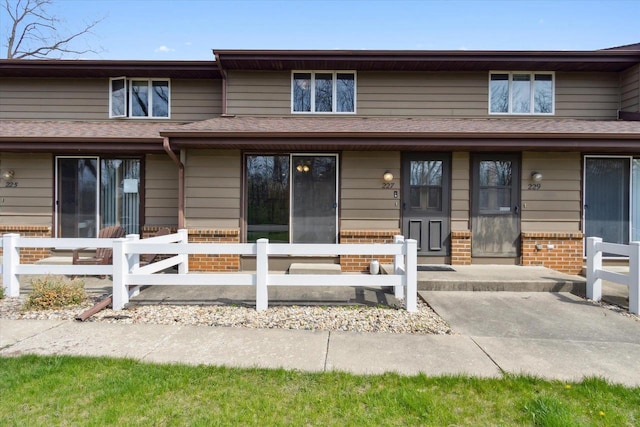 view of front of property featuring brick siding and fence