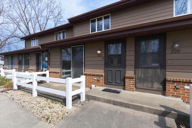 doorway to property featuring covered porch and brick siding