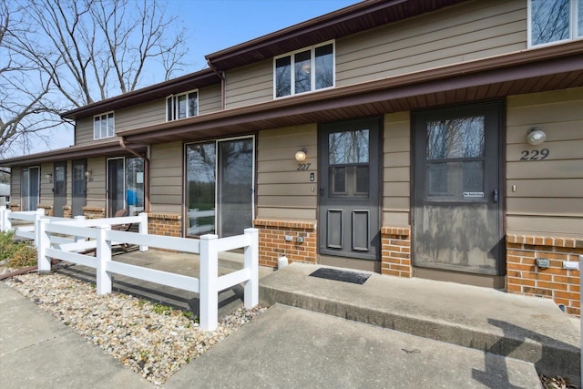 property entrance featuring brick siding and covered porch