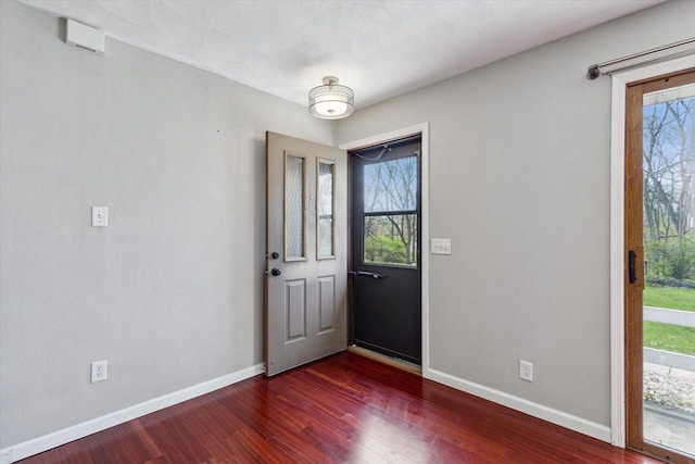 entrance foyer featuring dark wood-type flooring, baseboards, and a healthy amount of sunlight