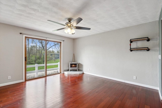 empty room featuring baseboards, a ceiling fan, and wood finished floors