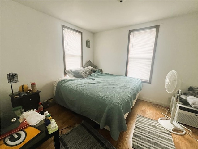 bedroom featuring wood finished floors and multiple windows