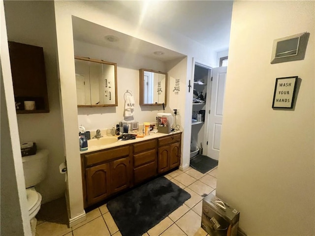 bathroom with tile patterned flooring, double vanity, toilet, and a sink