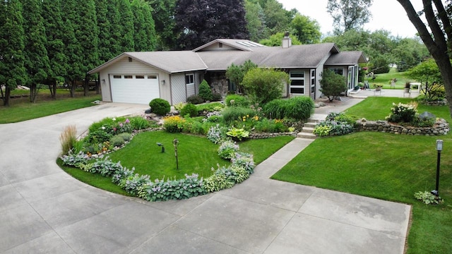 ranch-style home featuring a garage, driveway, a chimney, and a front lawn