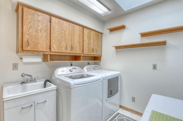washroom with cabinet space, independent washer and dryer, baseboards, and a sink