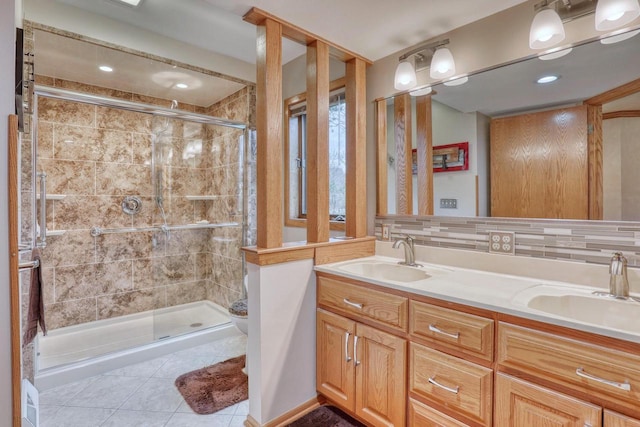 full bath with tile patterned floors, a sink, and a stall shower