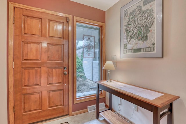 foyer with baseboards, visible vents, and light tile patterned floors