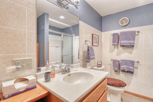 full bathroom with vanity, toilet, a stall shower, and tile walls
