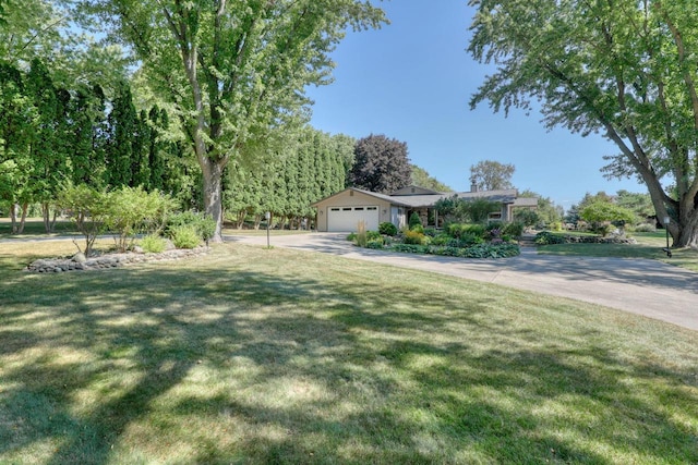 view of front of house featuring a garage, driveway, and a front lawn