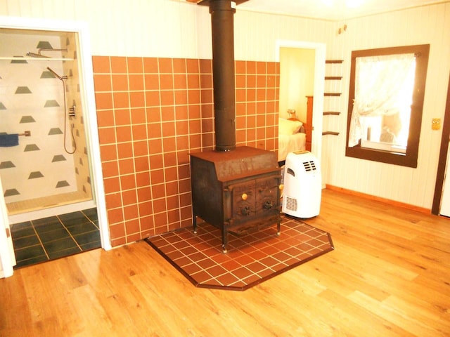 interior details featuring baseboards, a wood stove, and wood finished floors