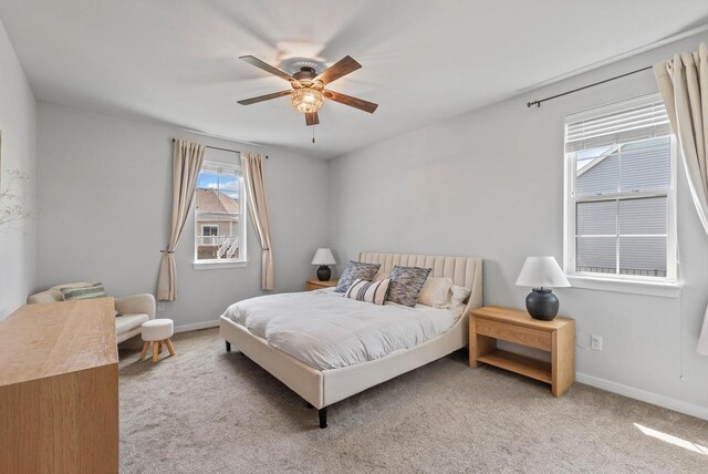 carpeted bedroom featuring baseboards and ceiling fan