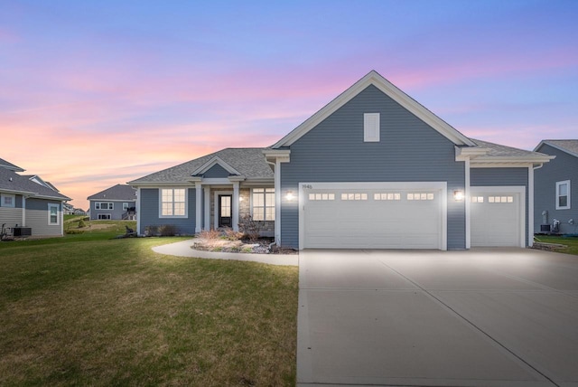 ranch-style house featuring roof with shingles, a garage, central AC, a front lawn, and concrete driveway