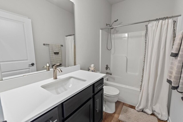 bathroom with vanity, shower / bath combo with shower curtain, toilet, and wood finished floors