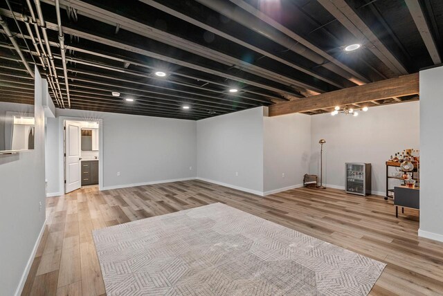 finished basement with baseboards, light wood finished floors, and wine cooler