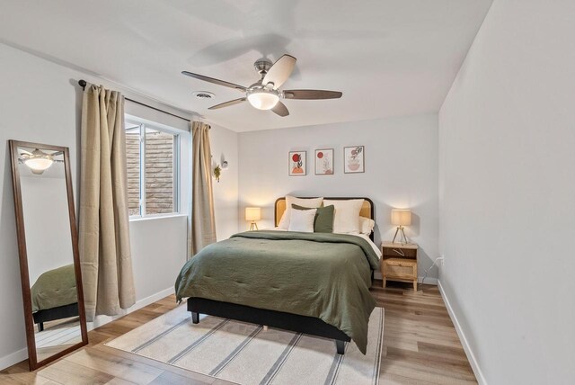 bedroom featuring baseboards, ceiling fan, light wood finished floors, and visible vents