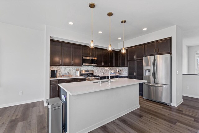 kitchen with dark brown cabinets, a sink, light countertops, stainless steel appliances, and dark wood-type flooring