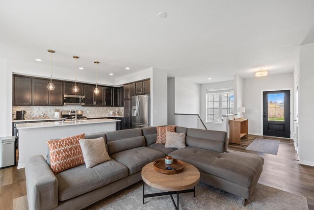 living area with baseboards, recessed lighting, and wood finished floors