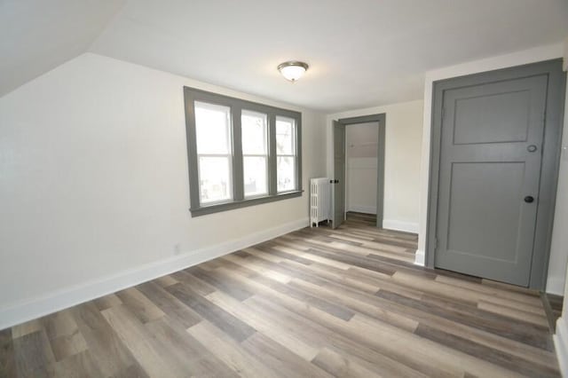 3736 E Edgerton Ave, Cudahy, WI 53110 - unfurnished bedroom with radiator heating unit, baseboards, vaulted ceiling, and wood finished floors