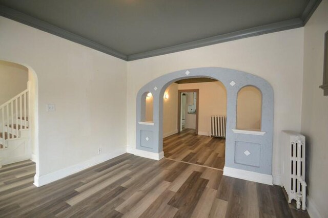 3736 E Edgerton Ave, Cudahy, WI 53110 - empty room featuring radiator heating unit, dark wood-style floors, and ornamental molding