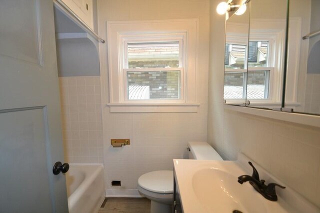 3736 E Edgerton Ave, Cudahy, WI 53110 - bathroom with tile walls, a tub to relax in, vanity, and toilet