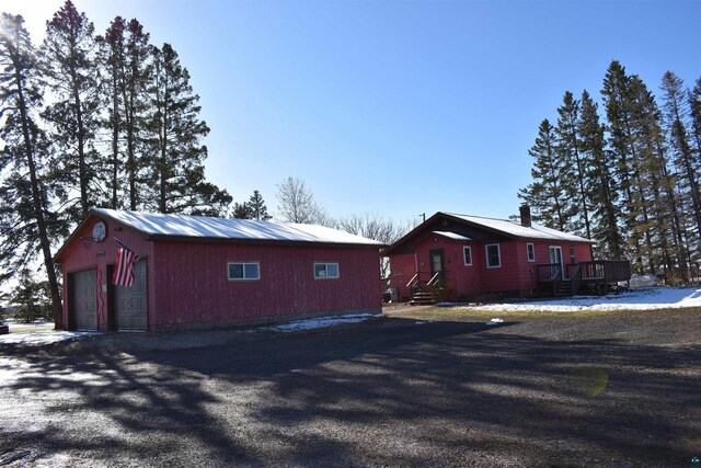 71435 Range Line Rd, Iron River, WI 54847 - view of snow covered exterior with an outbuilding, a deck, and a garage