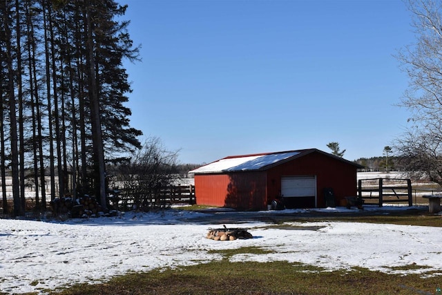 71435 Range Line Rd, Iron River, WI 54847 - snow covered structure featuring a fire pit, fence, and an outbuilding