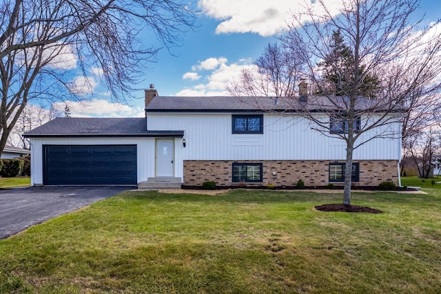 2941 Chapel Ln, Mount Pleasant, WI 53406 - split level home featuring a chimney, a front lawn, aphalt driveway, a garage, and brick siding