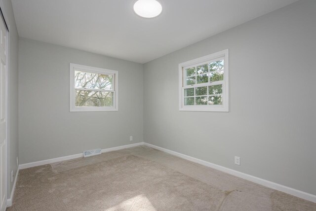 2941 Chapel Ln, Mount Pleasant, WI 53406 - spare room featuring carpet, baseboards, visible vents, and plenty of natural light