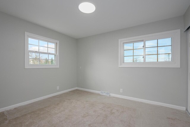 2941 Chapel Ln, Mount Pleasant, WI 53406 - carpeted spare room with visible vents, baseboards, and a wealth of natural light