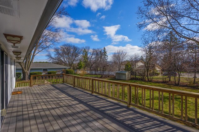 2941 Chapel Ln, Mount Pleasant, WI 53406 - wooden deck featuring a storage shed, an outbuilding, a fenced backyard, visible vents, and a lawn