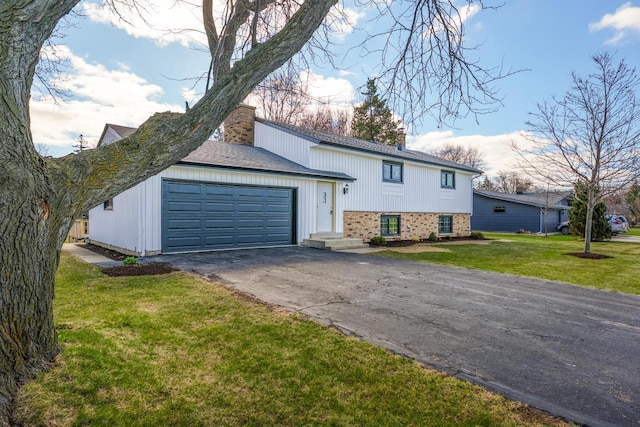 2941 Chapel Ln, Mount Pleasant, WI 53406 - view of front of property with a front lawn, an attached garage, a chimney, and aphalt driveway