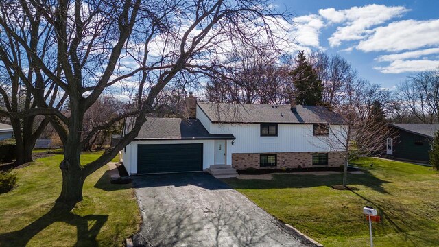 2941 Chapel Ln, Mount Pleasant, WI 53406 - view of front of home featuring a chimney, a front lawn, driveway, a garage, and brick siding