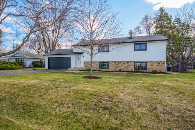 2941 Chapel Ln, Mount Pleasant, WI 53406 - tri-level home featuring a chimney, aphalt driveway, a front yard, and a garage