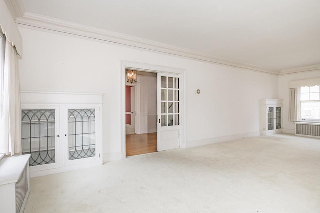 328 Wilson St, Winona, MN 55987 - unfurnished living room with radiator heating unit, french doors, crown molding, and carpet