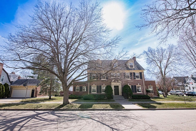 328 Wilson St, Winona, MN 55987 - view of front facade featuring brick siding, a garage, driveway, and a front yard