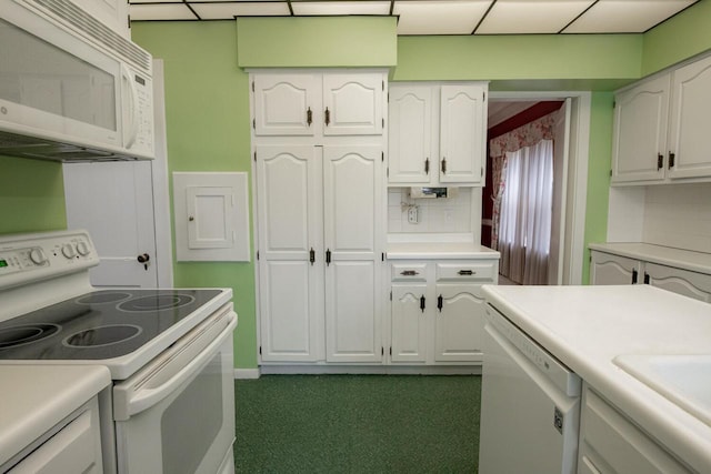 328 Wilson St, Winona, MN 55987 - kitchen with decorative backsplash, white appliances, light countertops, dark carpet, and white cabinetry