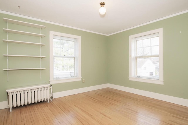 328 Wilson St, Winona, MN 55987 - empty room featuring ornamental molding, wood-type flooring, baseboards, and radiator heating unit