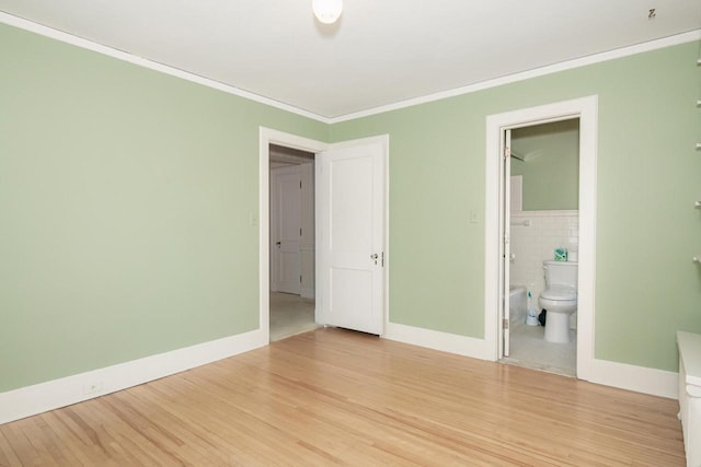 328 Wilson St, Winona, MN 55987 - unfurnished bedroom featuring wood finished floors, ensuite bath, and ornamental molding