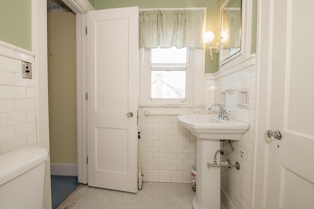328 Wilson St, Winona, MN 55987 - bathroom featuring tile walls, tile patterned flooring, wainscoting, and toilet