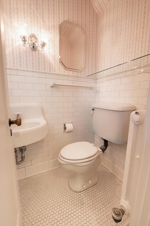 328 Wilson St, Winona, MN 55987 - half bath featuring wallpapered walls, tile patterned floors, and wainscoting